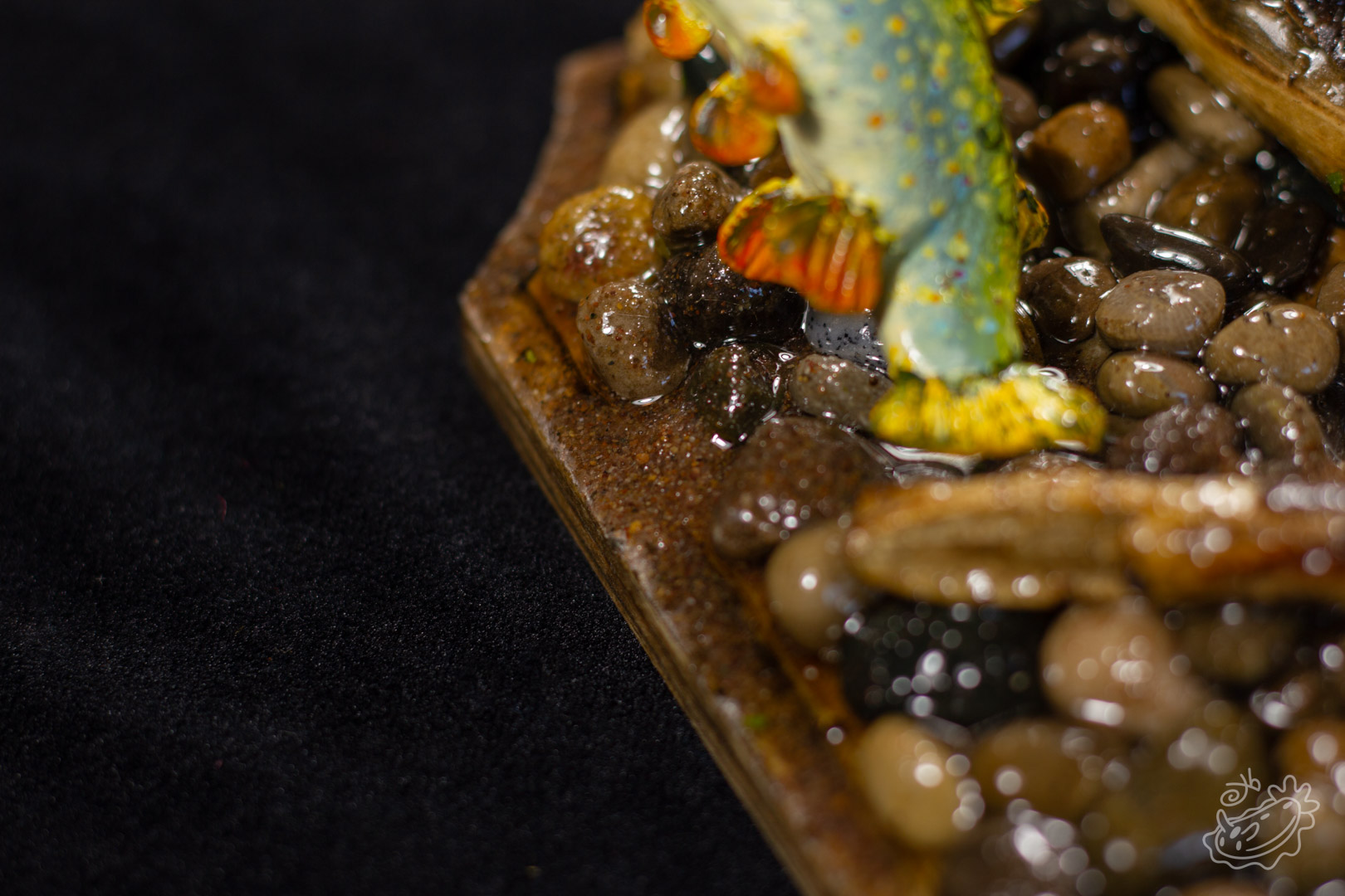 A close up on a model of a female Brook Trout creating a redd (nest) in gravel and sand
