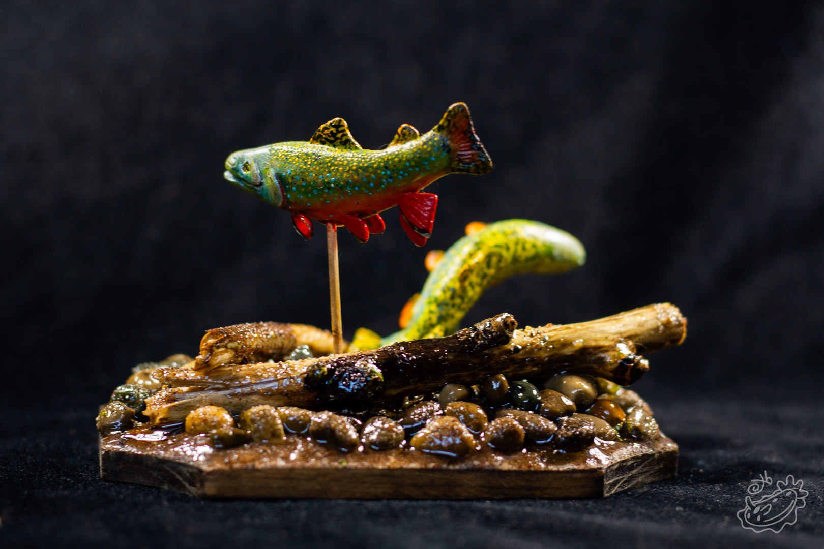 A model of two Brook Trout. The male swimming above and the female below creating a nest in the pebbles. Rear View.